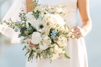 bride holding flowers in almond orchard