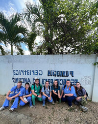 group of students sitting in front of wall