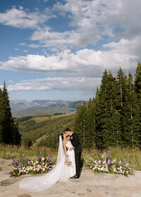 Groom kissing bride under veil