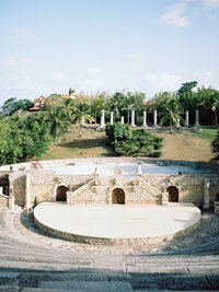 The historic amphitheater at Altos de Chavón surrounded by palm trees and stone architecture — iconic wedding venue in the Dominican Republic, captured by Asia Pimentel.