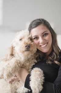 woman smiling while sitting next to dog