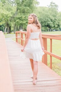 Girl in sundress looking over shoulder on Beaver Creek Trail bridge