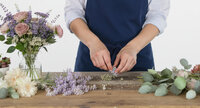 A florist at work cutting and tying stems.