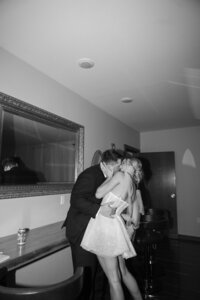 black and white photo of bride and groom kissing