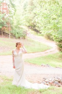 A bride looks off to the side and you can see a pathway behind her.