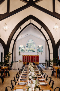 Photo of long reception table with arched wall in the background
