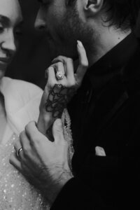 black and white photo of bride and groom, the bride has a tattooed hand