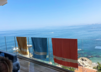 towels hanging over railing with a view of the ocean