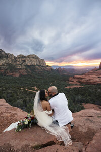 Bride and groom kissing at merry go round rock.
