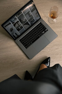 a woman standing by an open laptop 