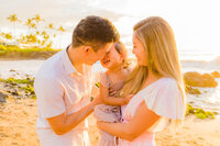 pregnant woman holding her belly at sunset wearing bright pink gown