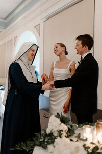 bride and groom chat with religious sister at wedding reception