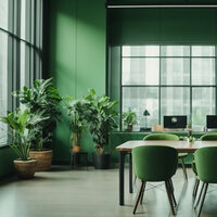 Modern office space with green walls, green chairs, large windows, and potted plants creating a fresh, natural vibe.