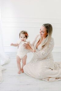 Babyfotoshooting: Babysberste Schritte an Hand festgehalten bei einem Babyfotoshooting.