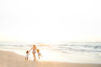 Family Photographer, a family walks on the sandstone cliffs beside the water