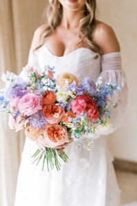 Romantic bridal bouquet with coral peonies and lavender florals, a signature wedding floral arrangement by Bloom Bar for Austin weddings.