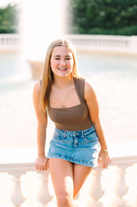 High school senior posing by a fountain, captured during a Virginia senior portrait session by a Virginia wedding photographer.