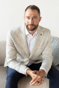 Founder of Meritus Group Business Brokerage seated confidently, representing the high-end, strategic brand experience showcased in the custom website design

