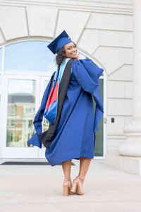 Senior pictures of a young woman in a blue graduation gown and cap taken at her university campus in Dallas, TX