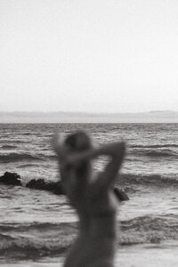 A woman at the beach looking out at the ocean.