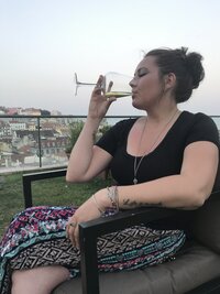 Hiliary sipping win on a roof top in Lisbon, Portugal while on a vacation backpacking trip in Europe