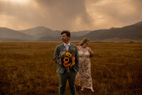 bride and groom stand in field in Buena Vista Colorado 