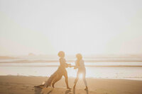 Blurry photo of couple running and holding hands in front of beach sunset