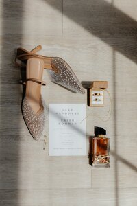 flat lay of brides shoes perfume and jewelry at wedding venue in texas
