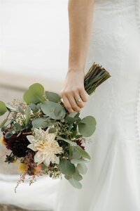 A bride holding her bouquet during a fall wedding on the shores of Lake Geneva, Wisconsin. Captured in a timeless and refined style by Alexia Rodriquez, a destination wedding photographer specializing in elevated, editorial wedding imagery.