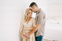 Springfield MO maternity photographer captures pregnant couple cuddling in studio