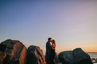 A couple kissing at the beach at sunset 