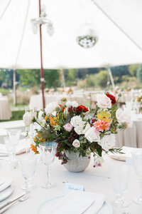 A floral arrangement sits on a table at a wedding, representing the planning process for event coordination and Boise wedding planning by Perfect Thirds & Co. 