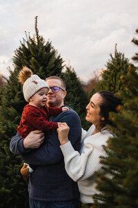Baby, mom and dad at Christmas tree farm in Cleveland