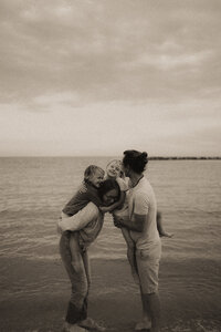 faire une photo de famille naturelle et calin sur la plage avec une photographe