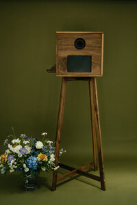 The Birdie Booth with a flower arrangement by it, representing the rental offerings of this Oregon photo booth. 
