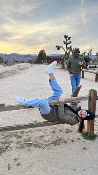 Girl hanging on fence in Joshua Tree