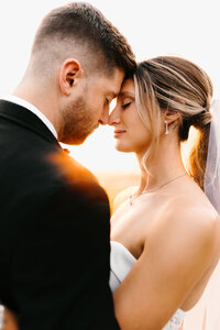 Bride and Groom touching foreheads and noses with eyes closed