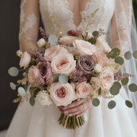 Bride holding her wedding bouquet of blush and mauve flowers.