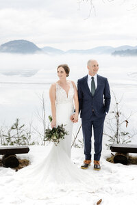 Married couple standing next to bench on the beach