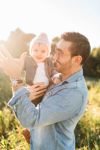 Father and child in sunny field
