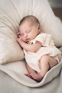 infant laying on blanket