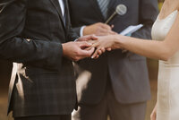 A couple putting their wedding ring on during a wedding ceremony at a Langley Farm.