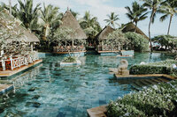 Tropical Polynesian pool retreat with cascading steps and secluded cabanas for ultimate relaxation.