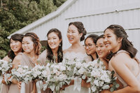 Bride and bridesmaids smiling with flower bouquets