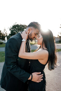 Sanjesh and Niyanta standing together holding one another during their engagement photoshoot, captured with warm sunflare by Auckland proposal photographer Zanthe Vorsatz.