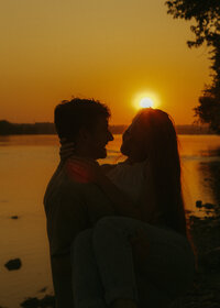 cinematic silhouette of couple with sunset reflecting on the lake 