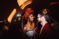 A black bride dressed in traditional Nigerian wedding attire dances with her groom