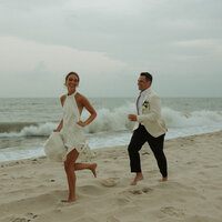Joyful couple running on the beach after a destination wedding in Delaware