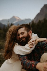 couple embracing in front of mountainscape