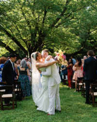 A bride and groom holding on to each other kissing at the end of their aisle at their wedding day in Tennessee. 